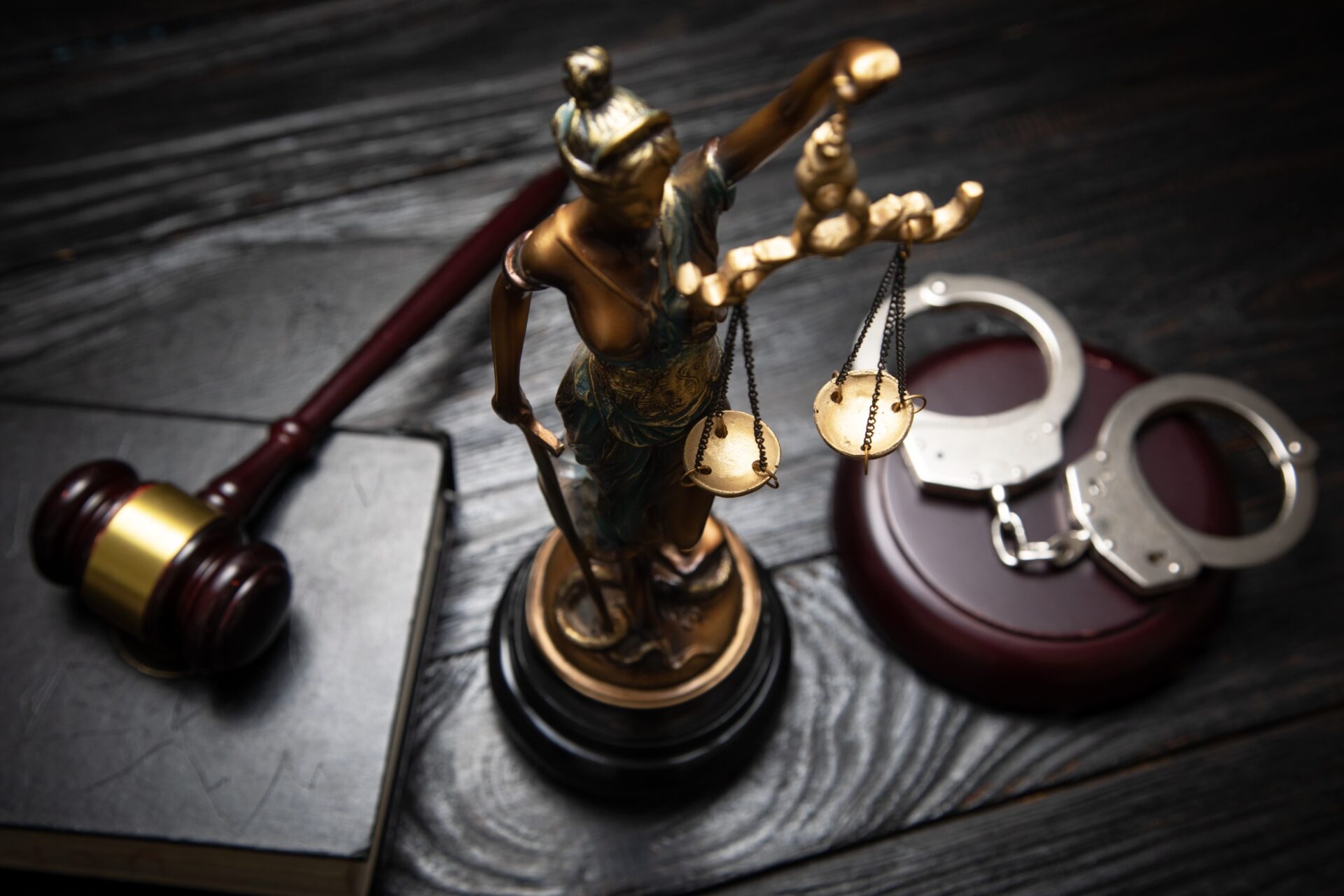 Statue of Lady Justice handcuffs book and gavel