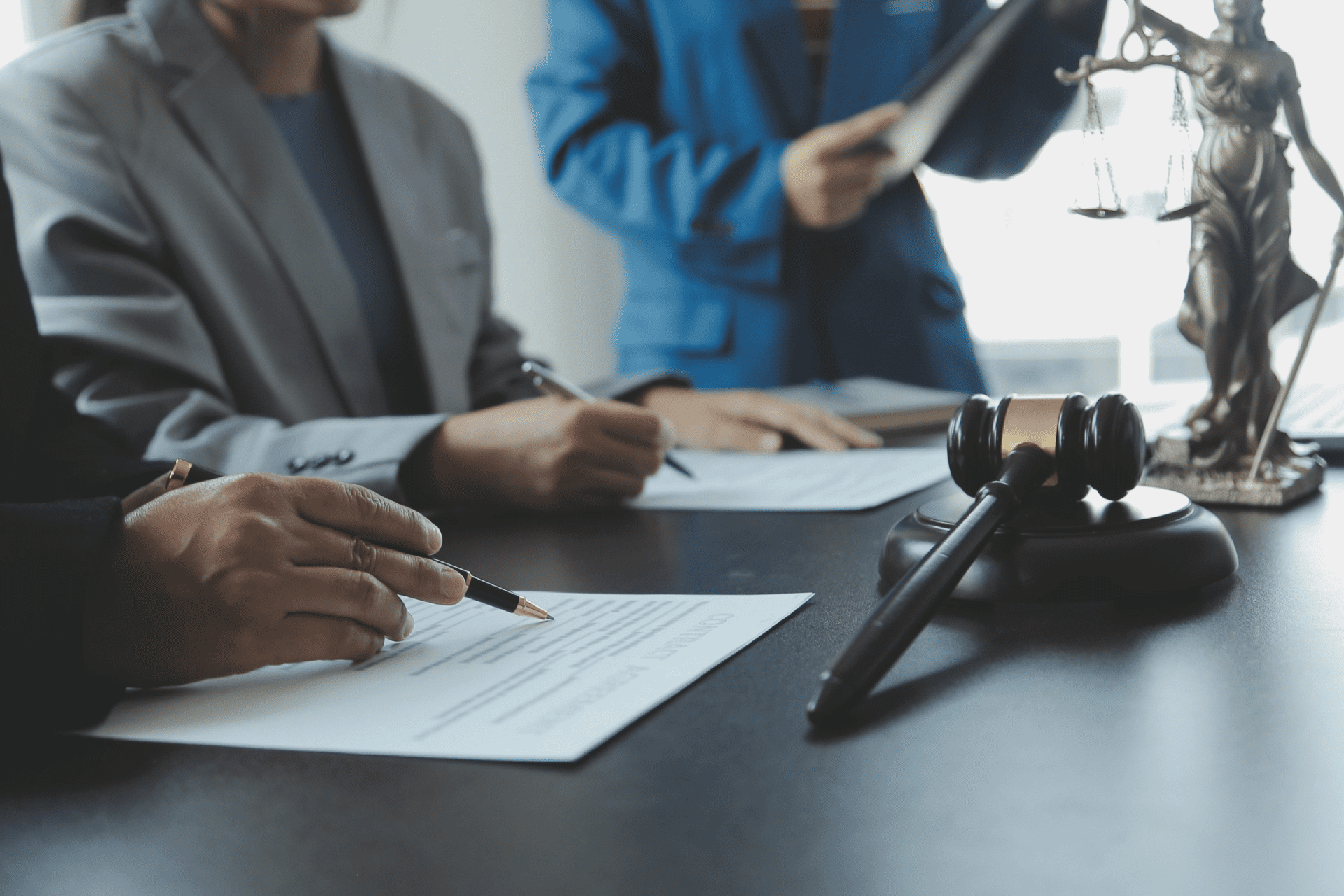 Male lawyer working with contract papers and wooden gavel on tabel in courtroom